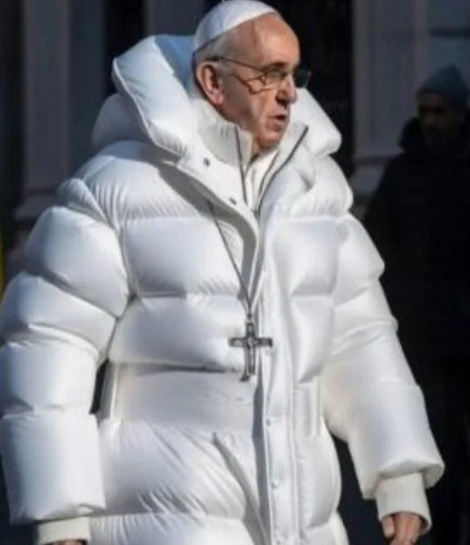 Imagem gerada por IA: o papa Francisco andando na rua com um casacão branco acolchoado e um crucifixo no peito.