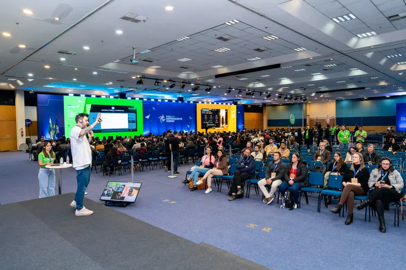 Auditório lotado assistindo a uma palestra de Gui Zanoni