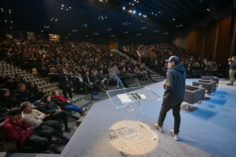 Gui Zanoni no palco diante de um auditório lotado em arquibancada