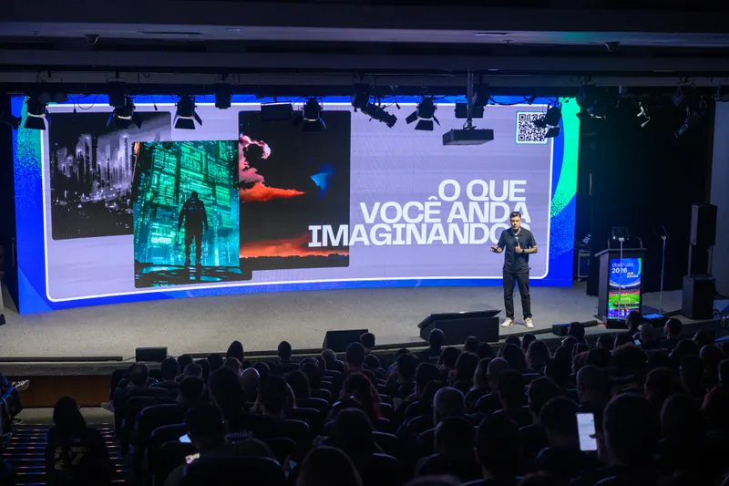 Gui Zanoni num palco grande, diante do telão com a pergunta O que você anda imaginando
