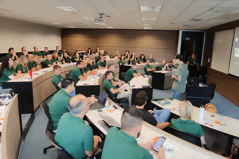 Turma de uniforme verde numa sala em anfiteatro, durante um workshop do Gui