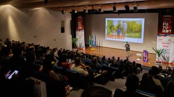 Gui Zanoni palestrando em auditório lotado